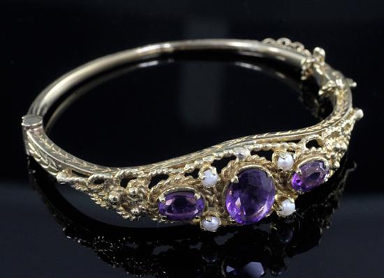 A 1970s Victorian style 9ct gold, amethyst and seed pearl set hinged bangle.